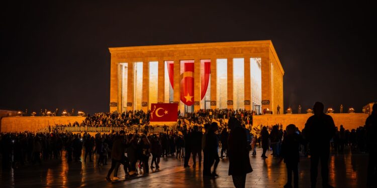 Gece saatlerinde aydınlatılmış Anıtkabir binası önünde toplanan kalabalık vatandaşlar