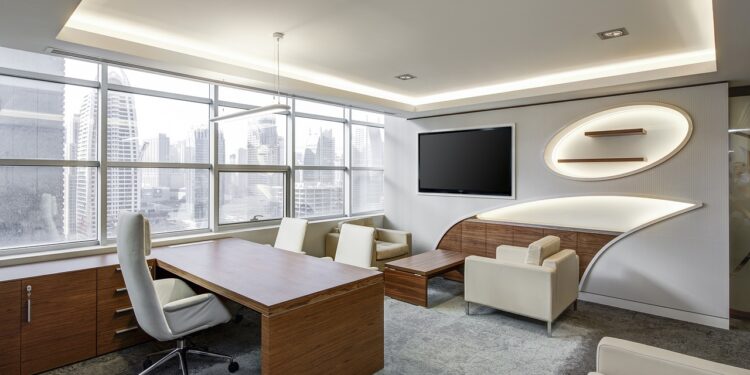 Şehir manzaralı geniş pencereleri olan modern bir ofis odası.