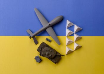 Mavi sarı zemin üzerinde dron, tank ve askeri engellerin yer aldığı maketler.