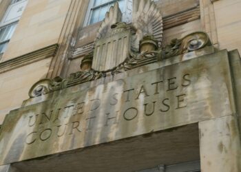 Üzerinde United States Court House yazan taş binanın giriş kısmının görünümü.