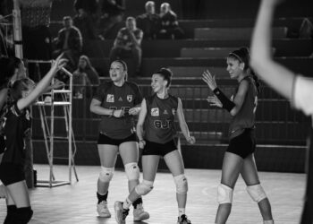 Siyah-beyaz karede voleybol oynarken sevinç yaşayan neşeli kadın sporcular yer alıyor.