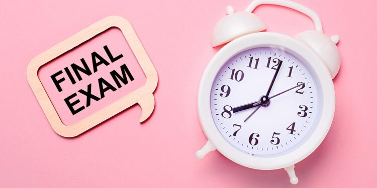 Üzerinde 'Final Exam' yazılı bir not kağıdı ve yanında çalar saat.