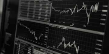 Bilgisayar ekranında finansal piyasaları ve hisse senedi grafiklerini gösteren ekran.