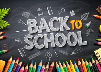 Kara tahta üzerinde tebeşirle yazılmış 'Back to School' yazısı ve okul malzemeleri.
