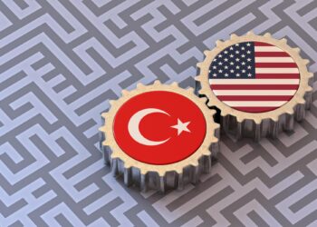 Türkiye ve ABD bayraklarının basılı olduğu metal dişliler gri zemin üzerinde.