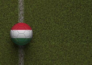 Çim sahada beyaz çizgi üzerine oturtulmuş Macaristan bayraklı futbol topu.